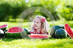 Little girl eating watermelon in the garden