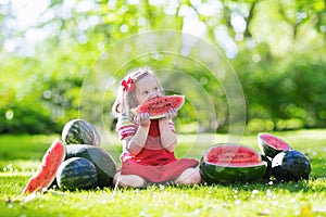 Little girl eating watermelon in the garden
