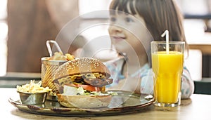 Little girl eats in a fast food cafe