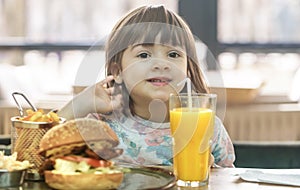 Little girl eats in a fast food cafe