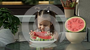 Little girl eats a juicy ripe watermelon with pleasure.