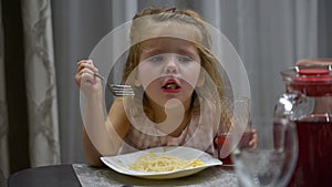 little girl eats pasta at lunch. The child choked on pasta and regurgitates them back into the plate