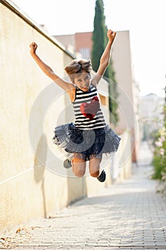 Little girl, eight years old, jumping outdoors.