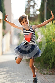 Little girl, eight years old, jumping outdoors.