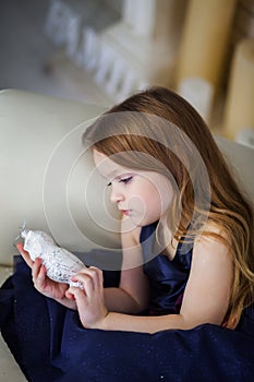 Little girl in an elegant dress sitting on a chair