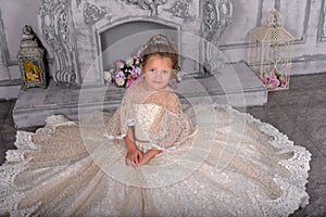 Little girl in elegant white Victorian dress in the interior