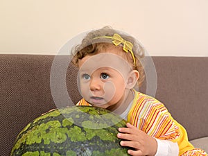 The little girl embraces hands big watermelon