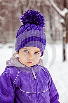 Little girl emotional portrait, closeup. Kid looking straight into the camera. Child walking outside.