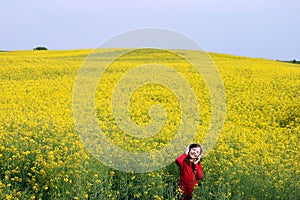 Little girl enjoy in music on yellow field summer season