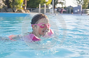 Little girl enjoying the summer at swiming pool