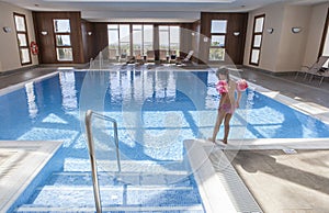 Little girl enjoying swimming pool indoors