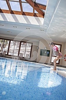 Little girl enjoying swimming pool indoors
