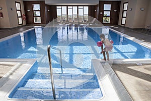 Little girl enjoying swimming pool indoors