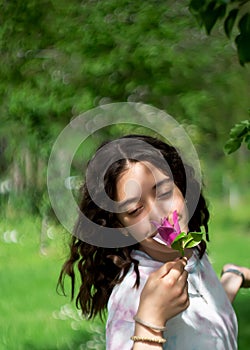 Little girl enjoys the smell of flowers