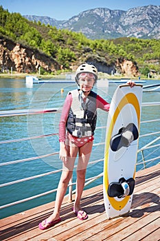 Little girl equipped for wakeboard sporting stands photo