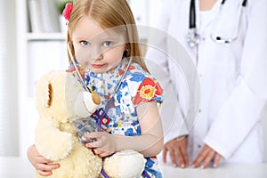 Little girl examining her Teddy bear by stethoscope. Health care, child-patient trust concept.