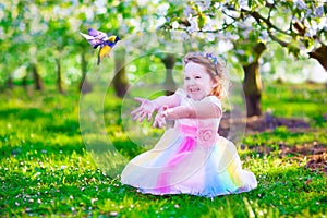 Little girl in fairy costume feeding a bird