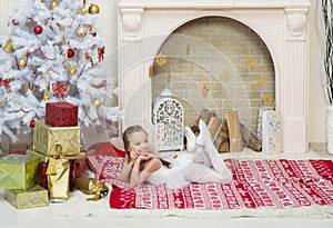 Little girl in fairy pixi costume dress is posing beside the Christmas tree