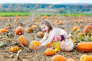 Little girl farming on pumpkin patch