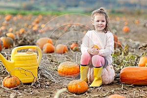 Little girl farming on pumpkin patch