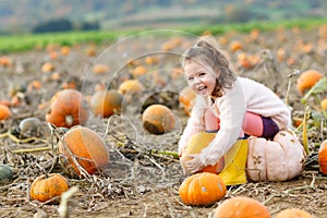 Little girl farming on pumpkin patch