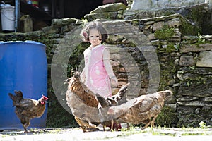 Little girl feeding chicken.