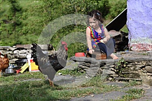 Little girl feeding chicken.