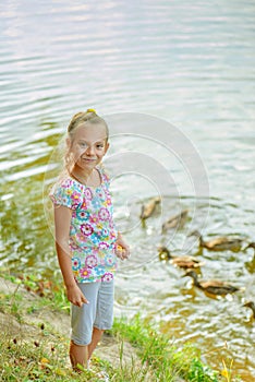 Little girl feeding ducks