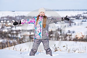 Little girl feeling happy at sunny winter weather