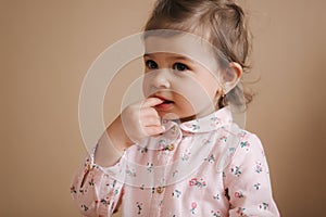 Little girl first time taste bithday cake. Cute little girl in beautiful dress tasting cake with strawberries