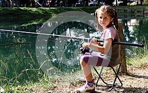 Little girl with the fishing rod on the shores of Lake fishing 1