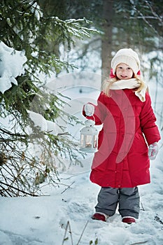 Little girl with a flashlight. Forest, winter day