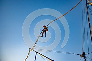 Little girl flies on elastic bands and jumps on a trampoline