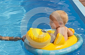 Little girl floating in the pool in rescue circle orange