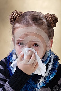 Little girl with the flu blowing her nose