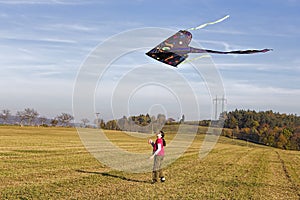 Little girl flying a kite in the sky.
