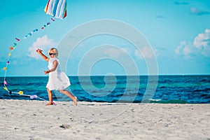 Little girl flying a kite at sky on beach