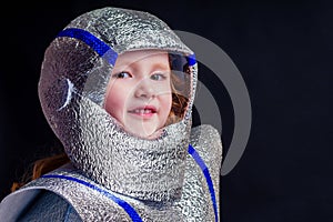 Little girl in foil diy space suit on a black background in the studio July 20, 1969 day of landing on the moon, child
