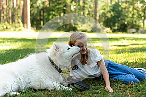 Little Girl in Forest Park Walking Playing with her Dog White Samoyed