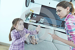 The little girl is frightened and protected from babysitting. She curses the girl and threatens her with a finger. photo