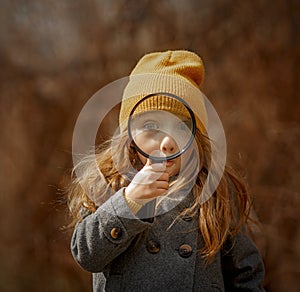 Little girl funny face  portrait with magnifier