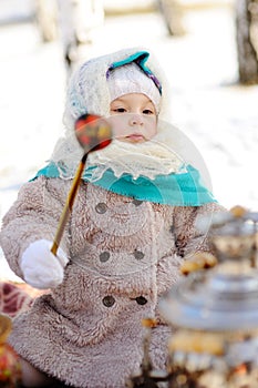 Little girl in a fur coat and a headscarf in the Russian style w