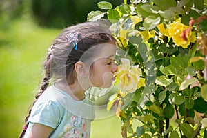 Little girl in the garden full of flowers