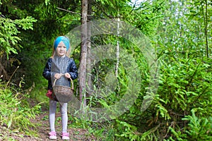 Little girl gathering mushrooms in autumn forest
