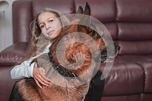 Little girl gently hugs her friendly big dog.