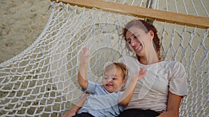 Little girl gently hugs mom in a hammock in a hammock slow motion stock. Baby is resting with a happy mother in a