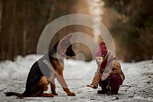 Little girl with German shepherd 6-th months puppy at early spring