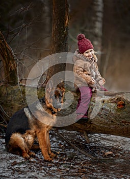Little girl with German shepherd 6-th months puppy at early spring