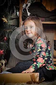 Little girl with gifts near a Christmas tree
