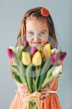 Little girl giving colorful flowers, smiling sincerely photo